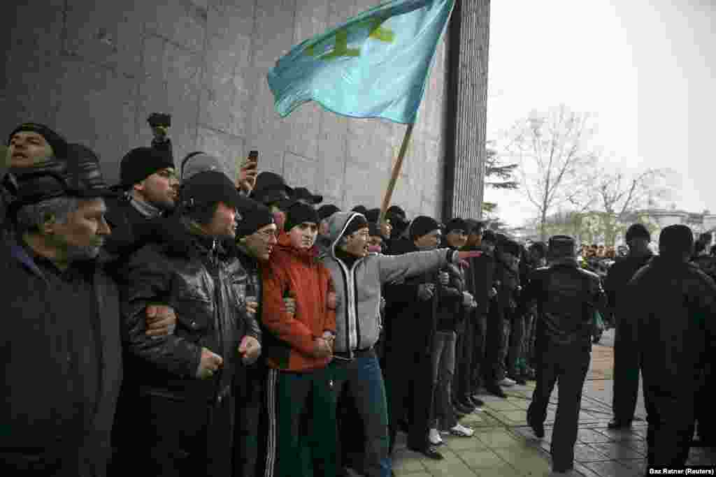 Крымские татары держат флаг своего народа во время митинга у парламента Крыма в Симферополе, 26 февраля 2014 года. Неделей ранее крымский политик поднял вопрос о возможности &laquo;отсоединения&raquo; полуострова от Украины. Протестующие на Майдане в Киеве в то время находились в процессе отстранения от власти пророссийского президента Виктора Януковича, позже эти протесты стали называть &laquo;революцией достоинства&raquo;. &nbsp;