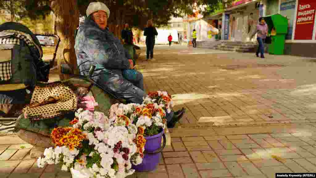 Пенсионерка торгует хризантемами на улице Гайдара