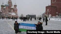 Мәскеудің Қызыл алаңында Өзбекстан туын ұстап отырған мигранттар. Туда "Қоқан" деген жазу бар. (Көрнекі сурет)