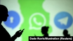 Silhouettes of mobile users are seen next to logos of social media apps Signal, Whatsapp and Telegram projected on a screen in this picture illustration taken March 28, 2018.