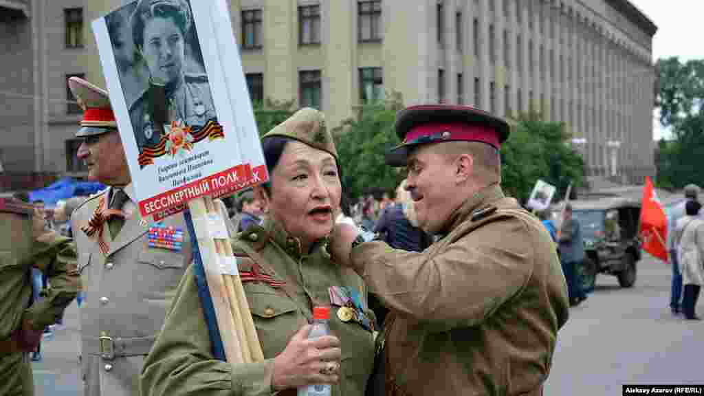 Ауғанстандағы соғысқа қатысқан полковник Сергей Пашевич даңқты 316-атқыштар дивизиясының әйгілі командирі генерал Иван Панфиловтың немересі Алуа Байқадамованың гимнастеркасы погонына әлденені тағып жатыр. Екеуі де екінші дүниежүзілік соғыс кезіндегі Қызыл армия жауынгері киімін киген.