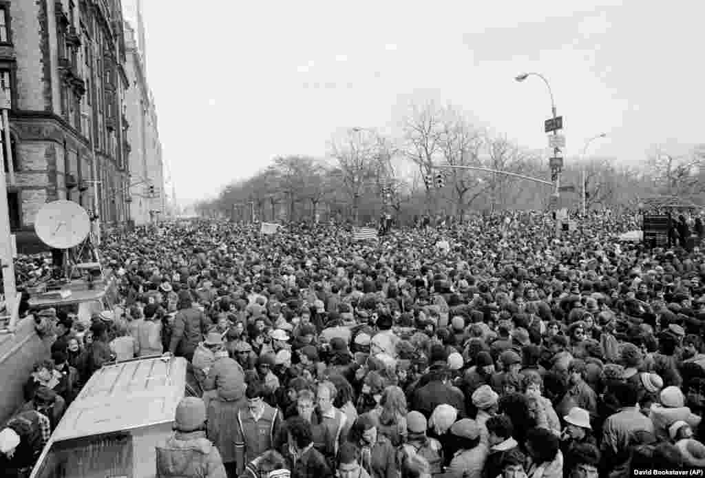 На этой фотографии из архива от 14 декабря 1980 года толпа перекрыла улицу Central Park West and 72nd Street в Нью-Йорке рядом с многоквартиным домом &laquo;Дакота&raquo;, где жил Джон Леннон, после того, как закончилась панихида, проходившая в Центральном парке